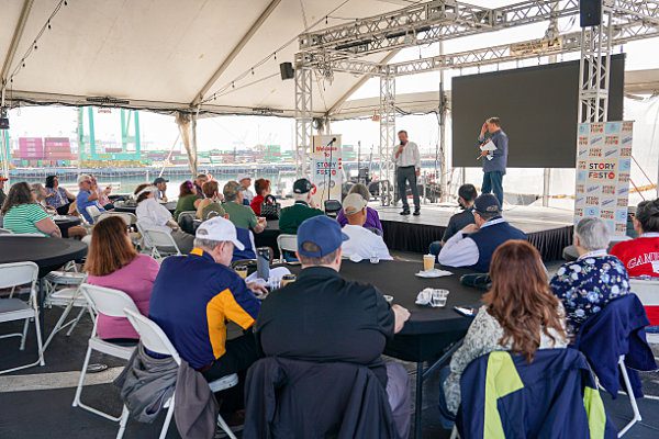 Marc Nguyen and Todd DePastino on a stage on the USS Iowa speaking to the audience