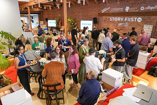 StoryFest attendees and authors talking in a large room.