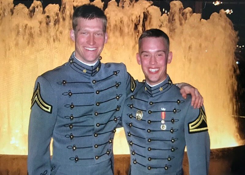 A smiling Nate Webster and another West Point cadet in front of a fountain in their dress uniforms