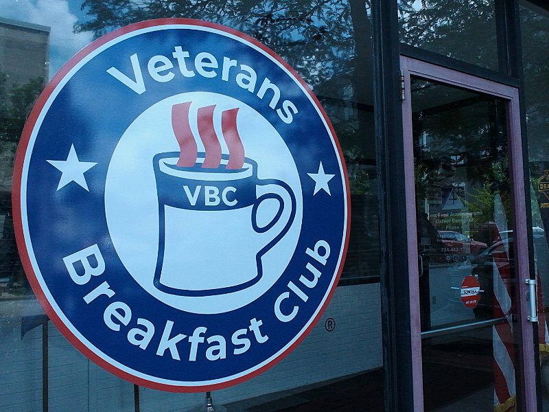 Large Veterans Breakfast Club logo sign on the glass doors of the new Welcome Center